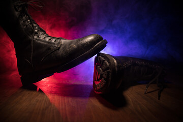 War concept. Old military shoe in a dark toned foggy background. Creative concept of conflict between countries, military aggression.