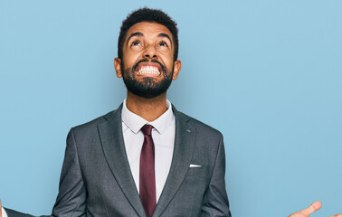 Young african american man wearing business clothes crazy and mad shouting and yelling with aggressive expression and arms raised. frustration concept.