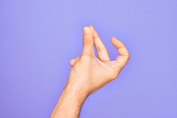 Hand of caucasian young man showing fingers over isolated purple background snapping fingers for success, easy and click symbol gesture with hand