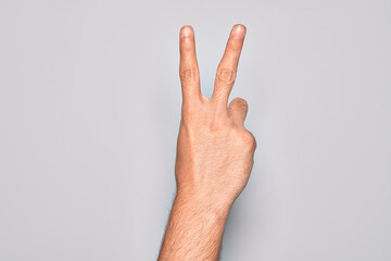Hand of caucasian young man showing fingers over isolated white background counting number 2...