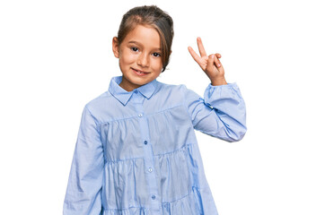 Little beautiful girl wearing casual clothes smiling with happy face winking at the camera doing victory sign. number two.