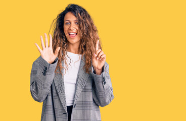 Young hispanic woman with tattoo wearing business oversize jacket showing and pointing up with fingers number six while smiling confident and happy.