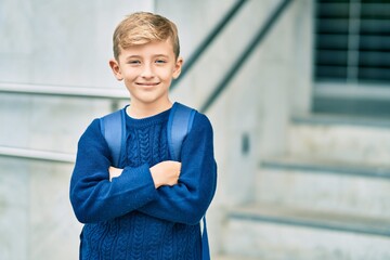 Adorable blond student kid smiling happy standing at the school.
