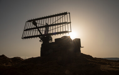 Space radar antenna on sunset. Silhouettes of satellite dishes or radio antennas against night sky....