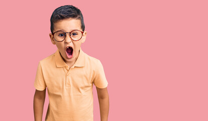 Obraz premium Little cute boy kid wearing casual clothes and glasses scared and amazed with open mouth for surprise, disbelief face
