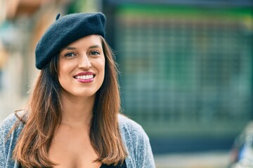 Young latin woman wearing french style standing at the city.