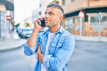 Young caucasian man smiling happy talking on the smartphone at the city.