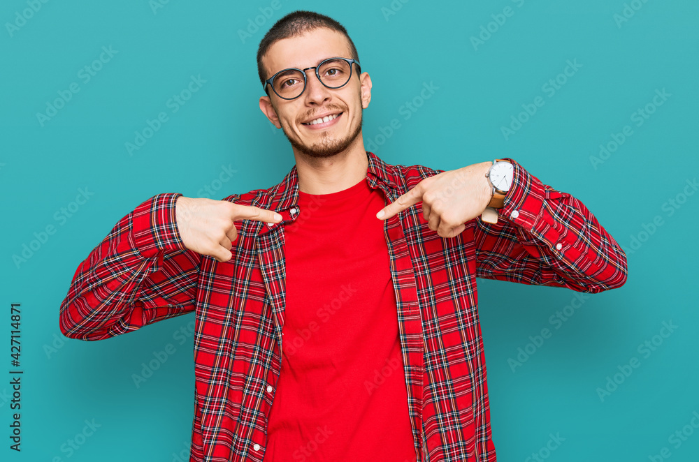 Wall mural hispanic young man wearing casual clothes looking confident with smile on face, pointing oneself wit