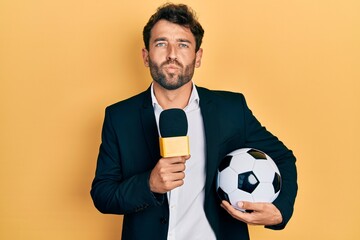 Handsome man with beard football reporter microphone looking at the camera blowing a kiss being...