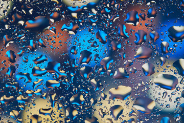 Neon lights behind water drops close up