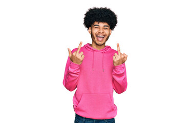 Young african american man with afro hair wearing casual pink sweatshirt showing middle finger doing fuck you bad expression, provocation and rude attitude. screaming excited