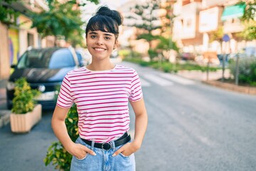 Young hispanic girl smiling happy walking at the city.