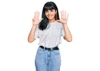 Young hispanic girl wearing casual clothes showing and pointing up with fingers number nine while...