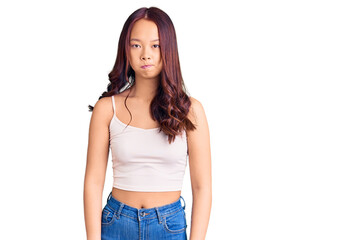 Obraz premium Young beautiful chinese girl wearing casual clothes puffing cheeks with funny face. mouth inflated with air, crazy expression.