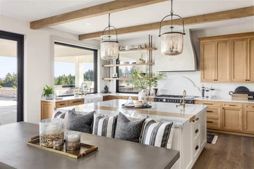 Foto op Canvas Traditional kitchen in beautiful new luxury home with hardwood floors, wood beams, and large island quartz counters. Includes farmhouse sink, elegant pendant lights, and large windows. © bmak