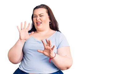 Young plus size woman wearing casual clothes disgusted expression, displeased and fearful doing...