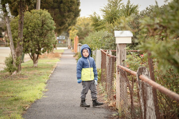 Winter walk with little boy wearing warm jacket with hood on secluded quiet footpath