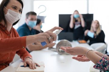 new normal businesspeople on meeting using antibacterial hand sanitizer