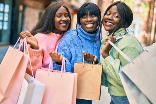 Three african american friends going shopping at the city.