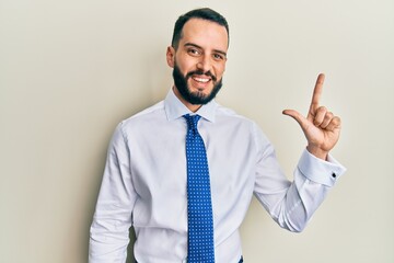 Young man with beard wearing business tie showing and pointing up with fingers number two while smiling confident and happy.