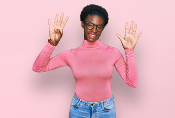 Young african american girl wearing casual clothes and glasses showing and pointing up with fingers...