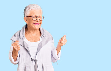 Senior beautiful woman with blue eyes and grey hair wearing casual clothes and glasses excited for success with arms raised and eyes closed celebrating victory smiling. winner concept.