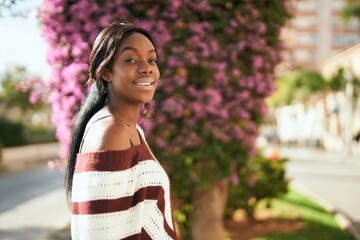 Young african american woman smiling happy standing at the park.