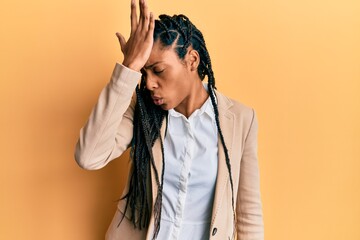 African american woman wearing business jacket surprised with hand on head for mistake, remember...