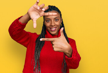 African american woman wearing casual winter sweater smiling making frame with hands and fingers with happy face. creativity and photography concept.