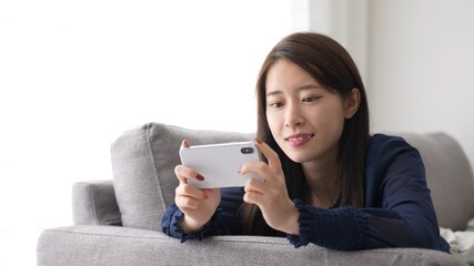 スマートフォンでゲームをプレイする女性