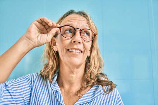 Middle age caucasian woman smiling happy standing at the city.