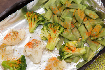 Baked in foil broccoli, string bean and cauliflower with spices close up. Vegan vegetarian healthy diet food	
