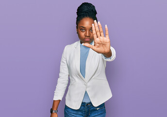 Young african american woman wearing business clothes doing stop sing with palm of the hand....
