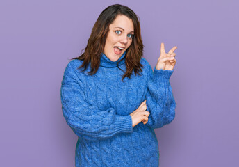 Young plus size woman wearing casual clothes smiling with happy face winking at the camera doing...
