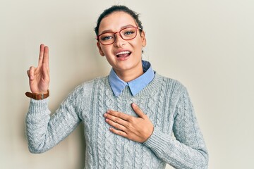 Young caucasian woman wearing casual clothes and glasses smiling swearing with hand on chest and...