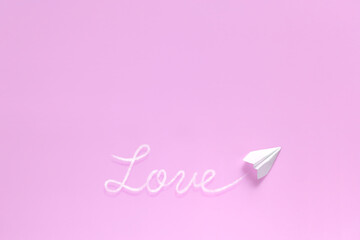 飛行機雲で文字を書く紙飛行機 1　love　ピンク背景