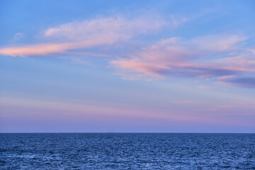 sunset and pink clouds over the blue calm sea