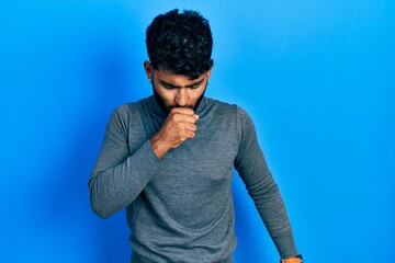 Arab man with beard wearing turtleneck sweater feeling unwell and coughing as symptom for cold or bronchitis. health care concept.