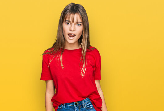 Teenager Caucasian Girl Wearing Casual Red T Shirt In Shock Face, Looking Skeptical And Sarcastic, Surprised With Open Mouth