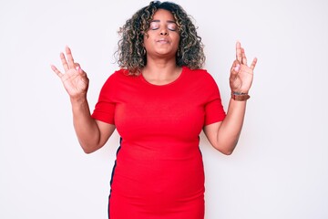 Young african american plus size woman wearing casual clothes relax and smiling with eyes closed doing meditation gesture with fingers. yoga concept.