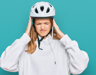 Beautiful young caucasian girl wearing bike helmet suffering from headache desperate and stressed because pain and migraine. hands on head.