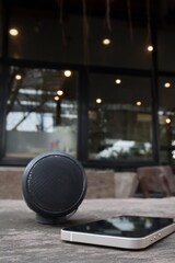 Bluetooth speaker and smart phone on brown wood background