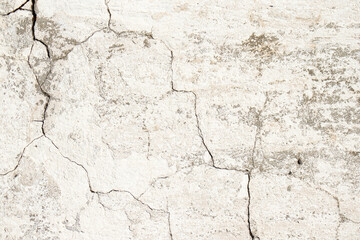 Old cracked cement plaster, whitewashed with white paint. In some places, a gray color is visible.