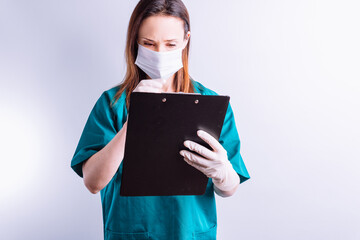 Fototapeta premium Hospital doctor with mask gloves on white background reading a full report medicine