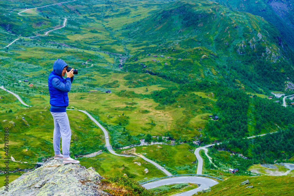 Wall mural tourist with camera and in norway mountains