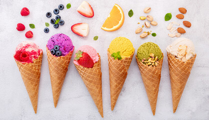 Various of ice cream flavor in cones blueberry ,pistachio ,almond ,orange and cherry setup on white stone background . Summer and Sweet menu concept. - 427138230