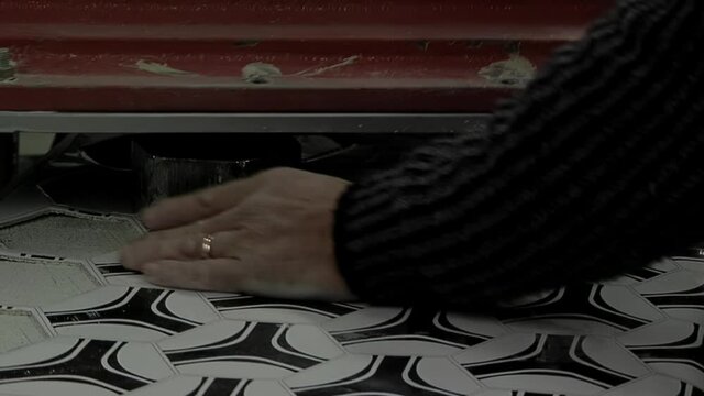 Worker Hand cutting Pieces of Synthetic Hexagons and Pentagons at a Football Ball Factory. Close Up.