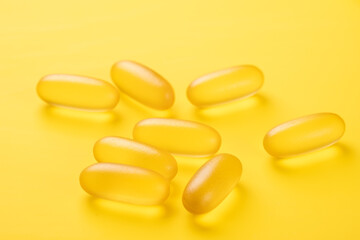 Close up Omega 3 capsules on yellow background. Fish oil softgels. Supplement food vitamin D capsules - Image