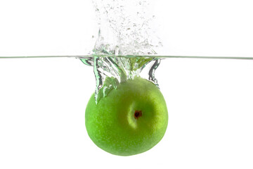 one green apple falling into water on a white background with splashes, drops and bubbles