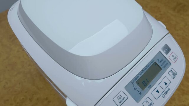 After completing the bread baking program, we take out the baked bread pan from the homemade bread machine and put the loaf on the table and enjoy the excellent result. Closeup